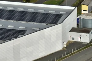 A white building with solar panels on top.